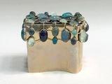 a silver box with a bunch of blue stones on it