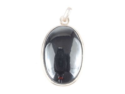 un gros plan d'un chat noir assis dans un pendentif en verre