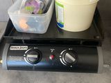 a black stove top with a container of food on top of it