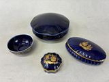 quatre objets en verre bleu ornés de motifs dorés posés sur une table