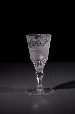 a wine glass sitting on a table with a black background