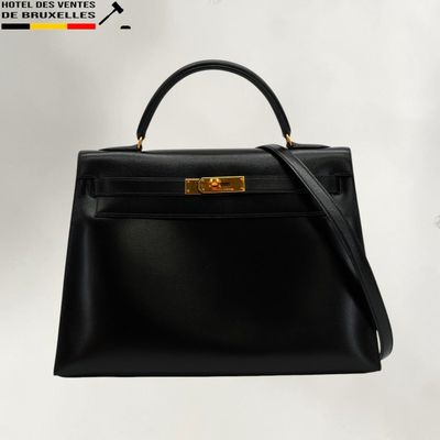 a black leather handbag with gold hardware on a white background