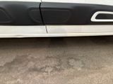 a white car with black trims parked in a parking lot