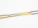 un bracelet à maillons dorés et argentés sur fond blanc