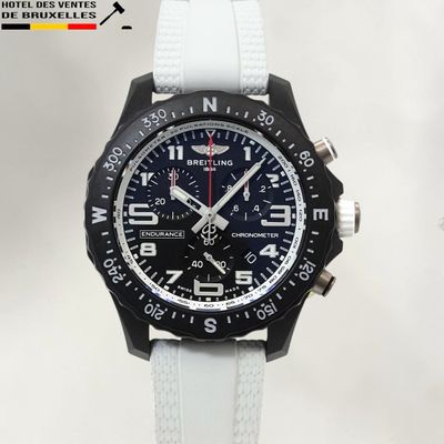 une photo d'une montre en noir et blanc avec une trotteuse rouge