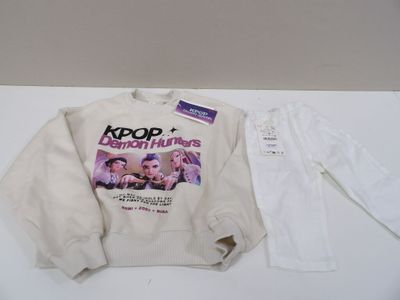the sweater is white and has a picture of a group of people on it