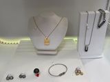 a display case with a necklace, bracelets, and other jewelry on it