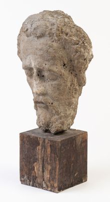 une image représentant une sculpture représentant une tête posée sur un bloc de bois
