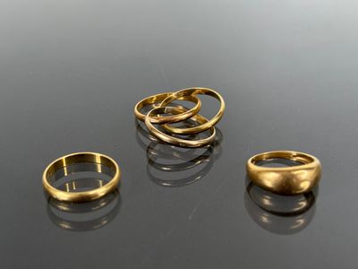 three gold rings sitting on top of a table next to each other