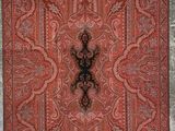 un vieux tapis orné d'une croix, accroché au mur