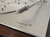a silver turntable with a white cord on it