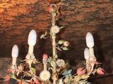 a chandelier with flowers on it in a room