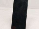 a black cell phone sitting on a stand on a white surface