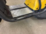 a yellow scooter with a metal plate on the front