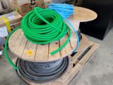 a green hose sitting on top of a wooden pallet