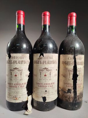 trois bouteilles de vin rouge posées côte à côte sur une table