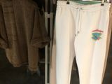 des vêtements suspendus à un portemanteau dans un magasin de vêtements, à côté d'un porte-manteaux