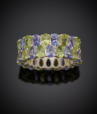 un gros plan d'une bague ornée de pierres vertes et bleues
