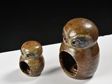 two ceramic owls that are sitting on a table