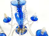un lustre en verre bleu surmonté d'un bougeoir