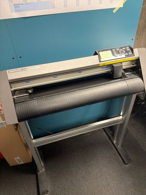 une machine posée sur le sol à côté d'une boîte