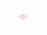 une bague sertie d'un saphir rose et de diamants sur fond blanc