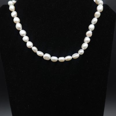 un collier de perles blanches sur un mannequin noir