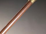 a close up of a wooden stick with a metal handle