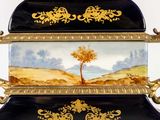 a black and gold vase with a painting on it