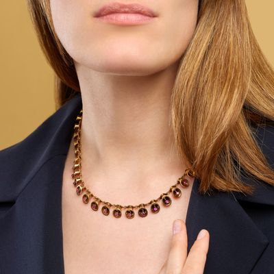 a woman in a black jacket and a gold necklace