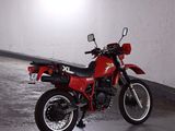 a red motorcycle parked in a parking garage