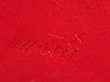 a close up of a red purse with a name engraved on it