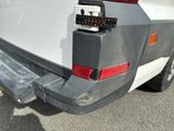 a white truck with a black bumper and a red tail light