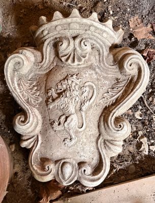 une plaque en pierre représentant un lion, posée au sol