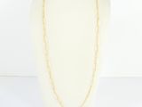 a white mannequin torso with a gold chain necklace on it