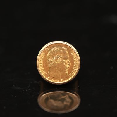 a gold coin sitting on top of a black surface