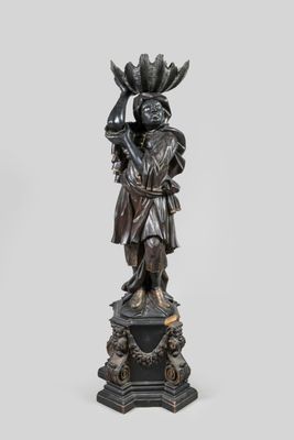une statue en bronze d'une femme tenant un oiseau sur un piédestal