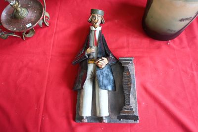 une figurine représentant un homme assis sur une table rouge