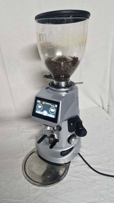 a coffee grinder sitting on top of a white sheet