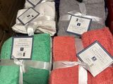 Des cartons contenant des serviettes assorties sont empilés les uns sur les autres