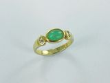 a close up of a gold ring with a green stone