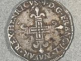 une vieille pièce d'argent ornée d'une croix, posée sur une table