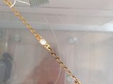 a gold bracelet with a white stone on it
