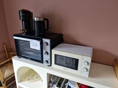 deux micro-ondes posés sur une étagère dans une pièce
