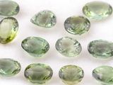 green tourmaline gems on a white surface with a white background