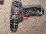 a cordless drill that is laying on the ground