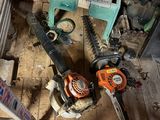 several chainsaws are sitting on a wooden floor in a room