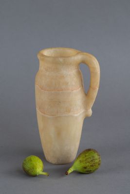 un vase muni d'une anse, avec deux figurines à côté