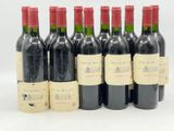 six bouteilles de vin rouge alignées sur une surface blanche