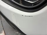 a close up of the front bumper of a white car